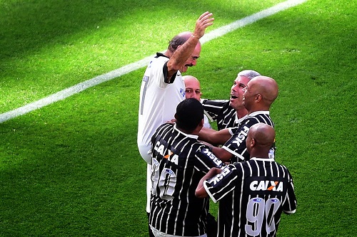 Jogadores comemorando o gol do Rivelino na Arena em jogo festivo 